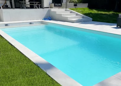 Construction d'une piscine en béton avec membrane armée, volet immergé et plage à Lille